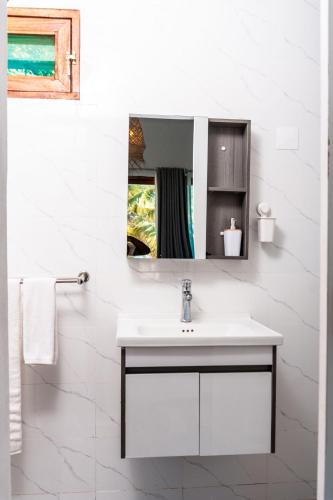 a white bathroom with a sink and a mirror at Giraffe House Vilankulo in Vilanculos