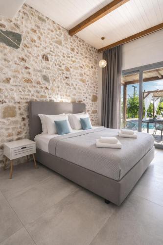 a bedroom with a large bed and a stone wall at Agorastos Luxury Living in Platamonas