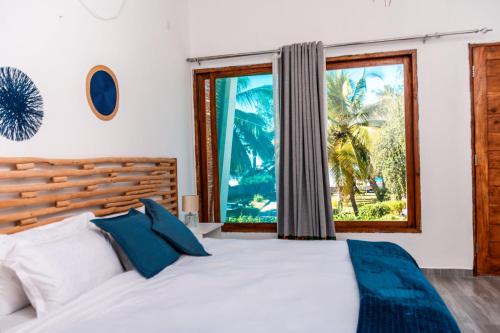 a bedroom with a large bed and a window at Giraffe House Vilankulo in Vilanculos