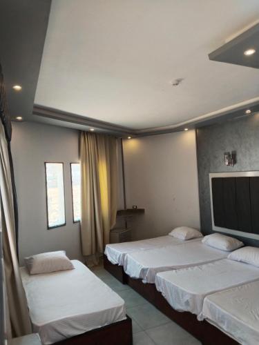 a room with two beds and a flat screen tv at Playa Hotel in Dahab
