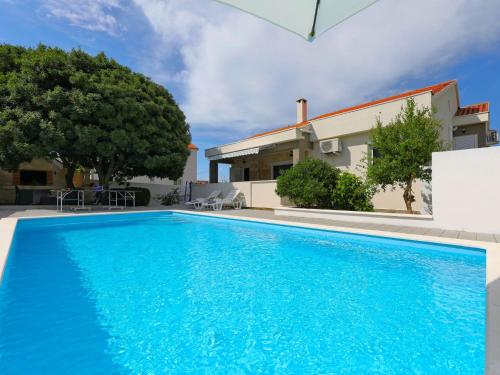 a swimming pool in front of a house at Holiday Home Karlo by Interhome in Posedarje