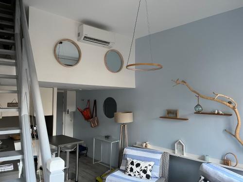 a room with a bed and a table and mirrors at La loge des Salinières in Bordeaux