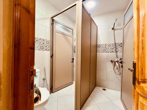 a bathroom with a shower and a toilet at Dar Surfana Surf Camp & Yoga Tamraght in Aourir