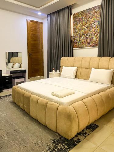 a large bed with a large tufted headboard in a bedroom at Super Star Midak Mews 2 in Lekki