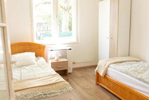 a bedroom with two beds and a window at Flóra Vendégház Balatonvilágos in Balatonvilágos