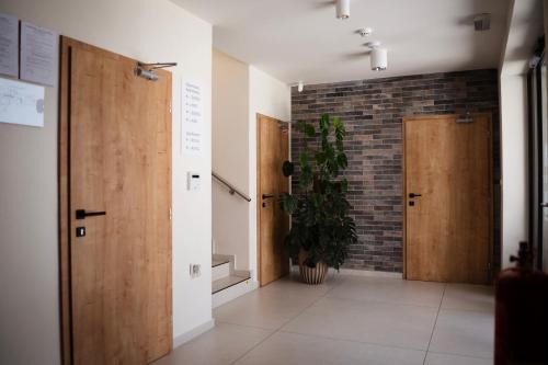 a hallway with wooden doors and a potted plant at LAMBERT Residences in Lučenec