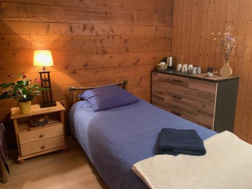 a bedroom with a bed and a table with a lamp at La Cure de Vernamiège in Vernamiège