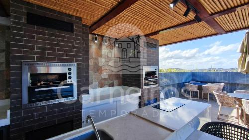 a kitchen with a fireplace on a patio at Makani Beach Campas - Praia de Tamandaré in Tamandaré