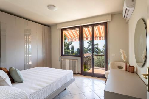 a bedroom with a bed and a balcony at Latte & Menta by Garda FeWo in Gardone Riviera