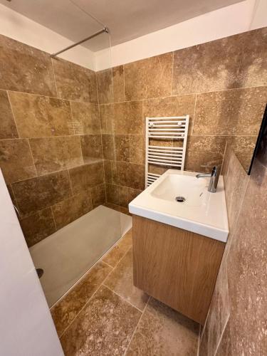 a bathroom with a sink and a shower and a tub at Le Petit Nid de Venelles in Venelles