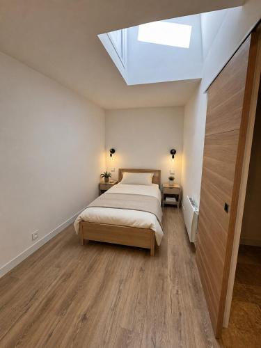 a bedroom with a bed and a skylight at Le Petit Nid de Venelles in Venelles