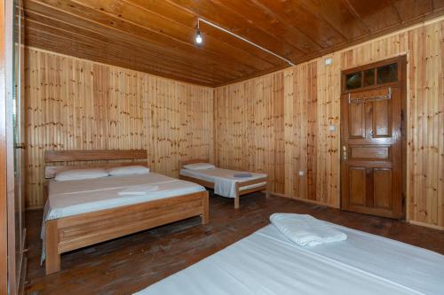 a room with two beds in a wooden cabin at Hotel Shen Klementi in Vermosh