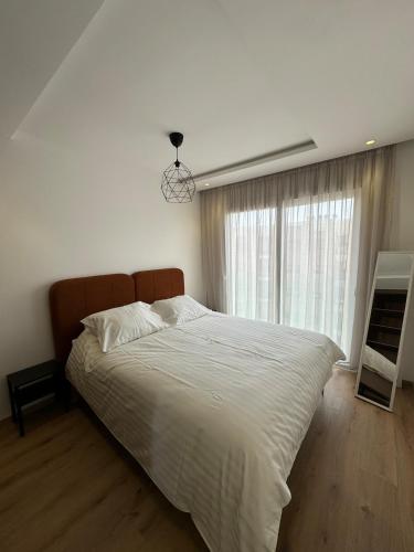 a bedroom with a large bed and a window at Charming apt with terrace in Kenitra