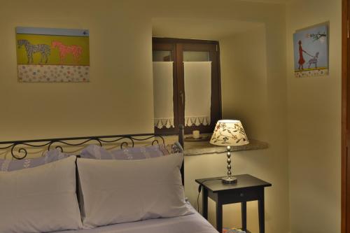 a bedroom with a bed and a table with a lamp at Gartagani Guest House in Stemnitsa