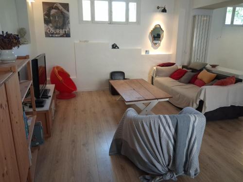 a living room with a couch and a table at Authentique maison de village à Agde avec patio in Agde