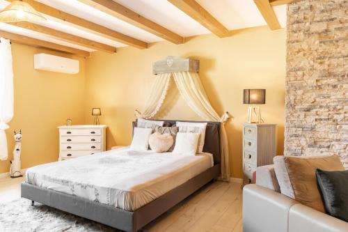 a bedroom with a large bed with a stone wall at Maison d'hôtes avec Jacuzzi -Sauna in Montreux-Château