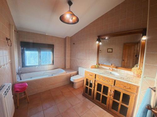 a bathroom with a tub and a toilet and a sink at Casa Rural La Vid in Cadalso de los Vidrios