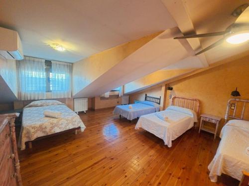 a room with two beds and two tables in it at Casa Rural La Vid in Cadalso de los Vidrios