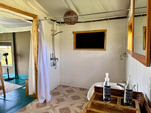 a bathroom with a shower and a tub and a sink at Kobe Mara in Talek