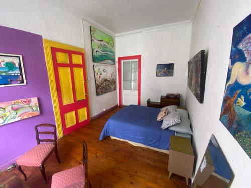 a bedroom with a blue bed and colorful walls at La Mancha Art Hostel - Cerro Alegre - Valparaiso in Valparaíso