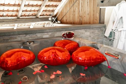 four red pillows sitting on top of a table at Maison d'hôtes avec Jacuzzi -Sauna in Montreux-Château