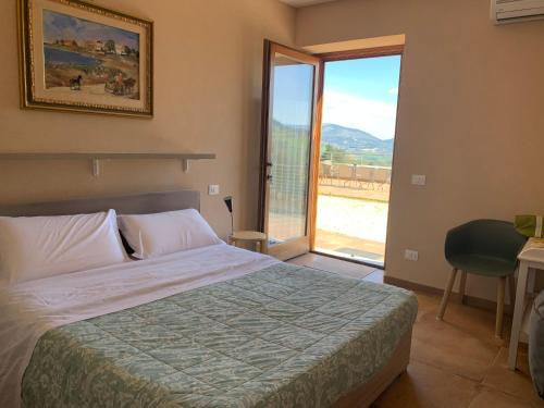 a bedroom with a bed and a large window at Green B&B Urbino Cá del vento in Urbino