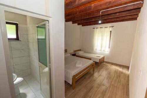 a small room with a bed and a bathroom at Hotel Shen Klementi in Vermosh