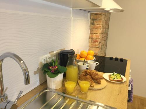 a kitchen counter with a plate of food and orange juice at Suur-Ameerika Apartment in Tallinn