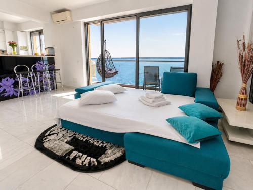 a large bed in a room with a large window at SOPHIA LAKE VIEW SUITE in Mamaia