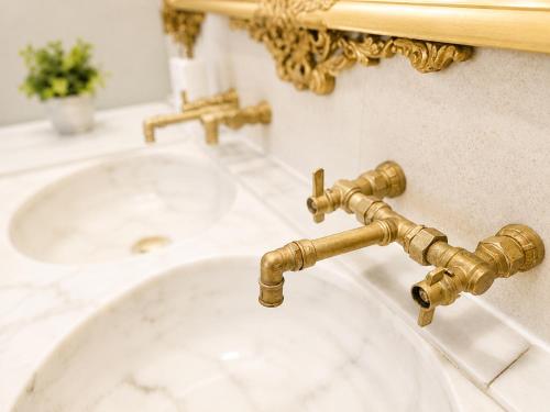 a bathroom sink with a gold faucet and a mirror at Chalet con piscina y barbacoa, Valencia in Torrent