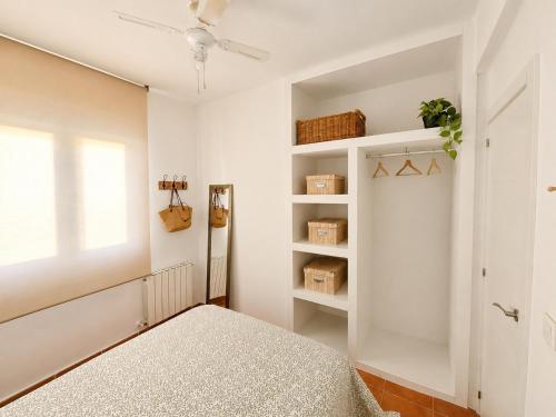 a white bedroom with a bed and a window at Chalet con piscina y barbacoa, Valencia in Torrent