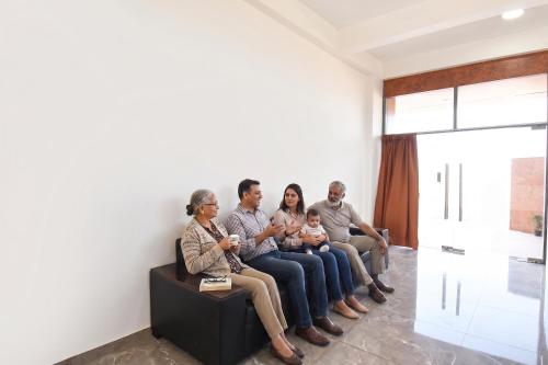 a family sitting on a couch in a room at FabHotel DSP in Pune