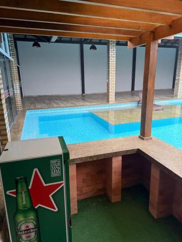 a bottle of beer sitting next to a swimming pool at Pousada Dona Maria in Pomerode