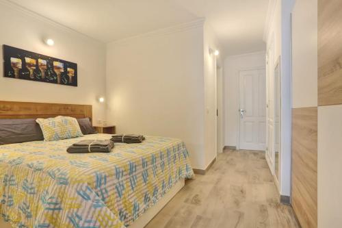 a bedroom with a bed with a yellow and blue blanket at GOLF Villa233 in San Miguel de Abona