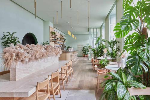 a large room with tables and chairs and plants at Eden Locke in Edinburgh