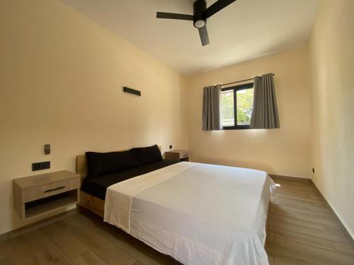 a bedroom with a white bed and a window at Villas 21 in Nosy Be