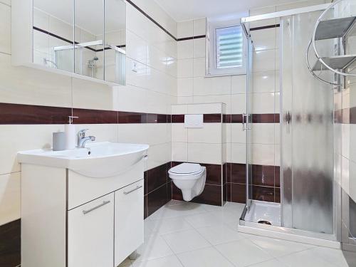 a bathroom with a toilet and a sink and a shower at House Gorica 2 - underground level apartments in Baška