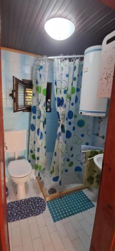un bagno con WC e tenda da doccia di Mizo Apartman a Bar
