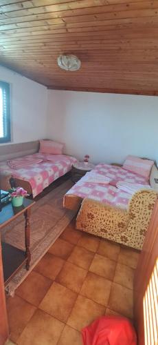 una camera da letto con due letti e soffitto in legno di Mizo Apartman a Bar