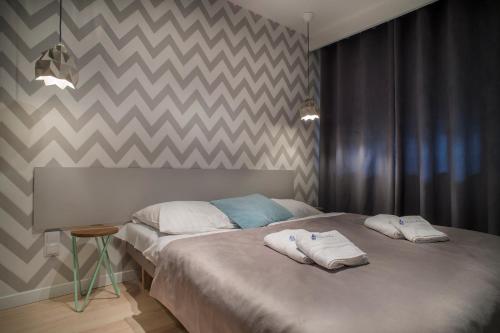 a bedroom with a bed with two towels on it at Apartamenty Nautilus in Świnoujście