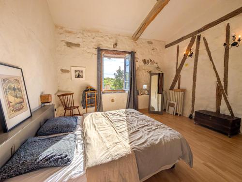 a bedroom with a large bed in a room at Maison Rives - Village du Livre de Montolieu in Montolieu