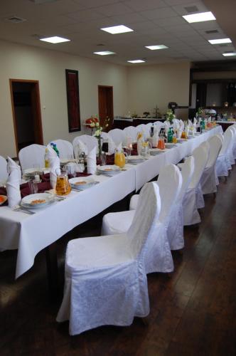 a long row of white tables with white chairs at Hotel Altamira in Piotrków Trybunalski
