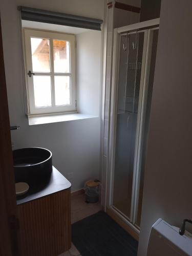 a bathroom with a sink and a shower with a window at La Maison du Bonheur in Jaujac
