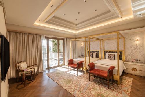 a bedroom with a canopy bed and two chairs at Taj Lalit Bagh, Udaipur in Udaipur