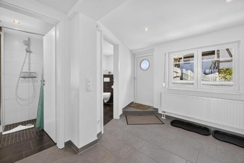 a bathroom with a walk in shower and a window at Ferienhaus Malebisa in Loddin