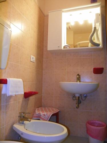 a bathroom with a sink and a toilet and a mirror at Hotel La Vela in Lido di Camaiore