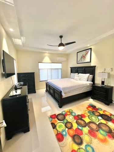 a bedroom with a bed and a large rug at ESEKK Ochi in Ocho Rios