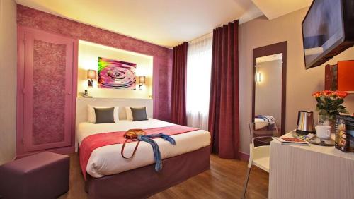 a hotel room with a large bed and a desk at The Originals City - Hôtel Saint-Martial, Limoges Centre in Limoges