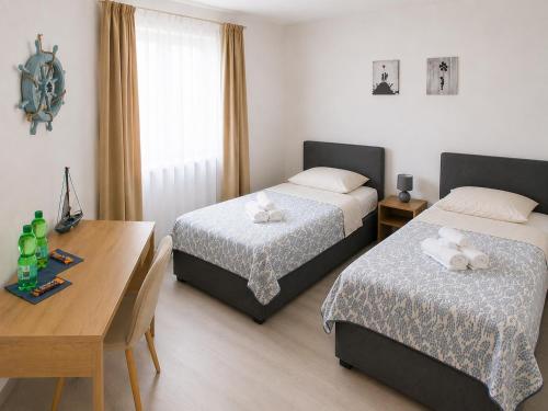 a room with two beds and a table and a desk at Hotel am Seehafen in Hamburg