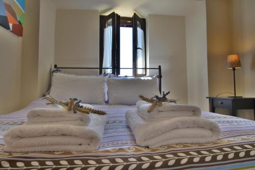 a bed with towels on it with a window at Gartagani Guest House in Stemnitsa